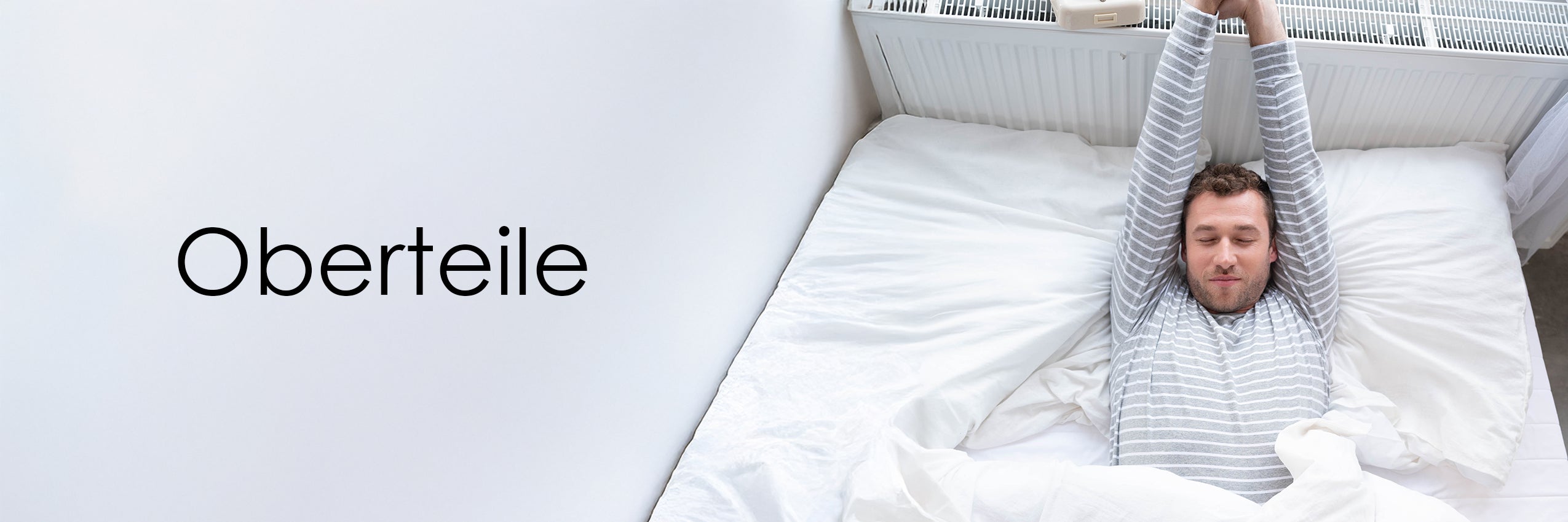 Mann im Bett mit geringeltem Pyjamaoberteil