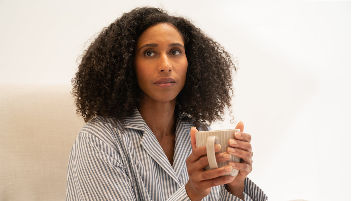 Frau im Schlafanzug Oberteil mit Kaffeetasse
